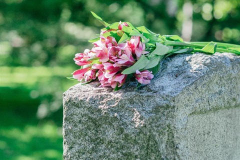Flowers placed on top of a gravestone.