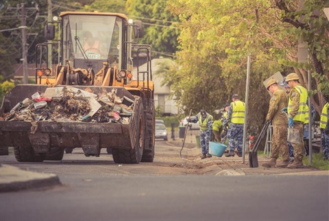 A bulldozer and army personnel assist with the streets clean-up after the 2022 flood.
