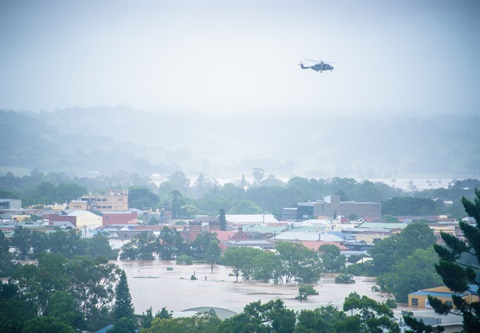 An army helicopter flies over flooded Lismore.
