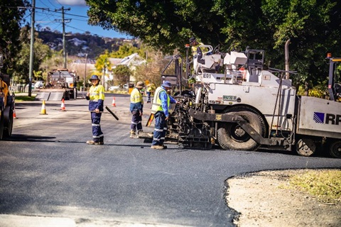 A road crew works on fixing a road.
