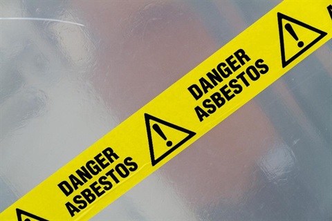 Yellow tape with the words danger asbestos on it.