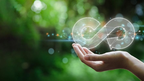 A graphic of and infinity symbol sitting in someone's hand with a green nature background.