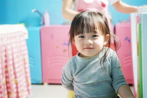 A young girl playing in a creche.