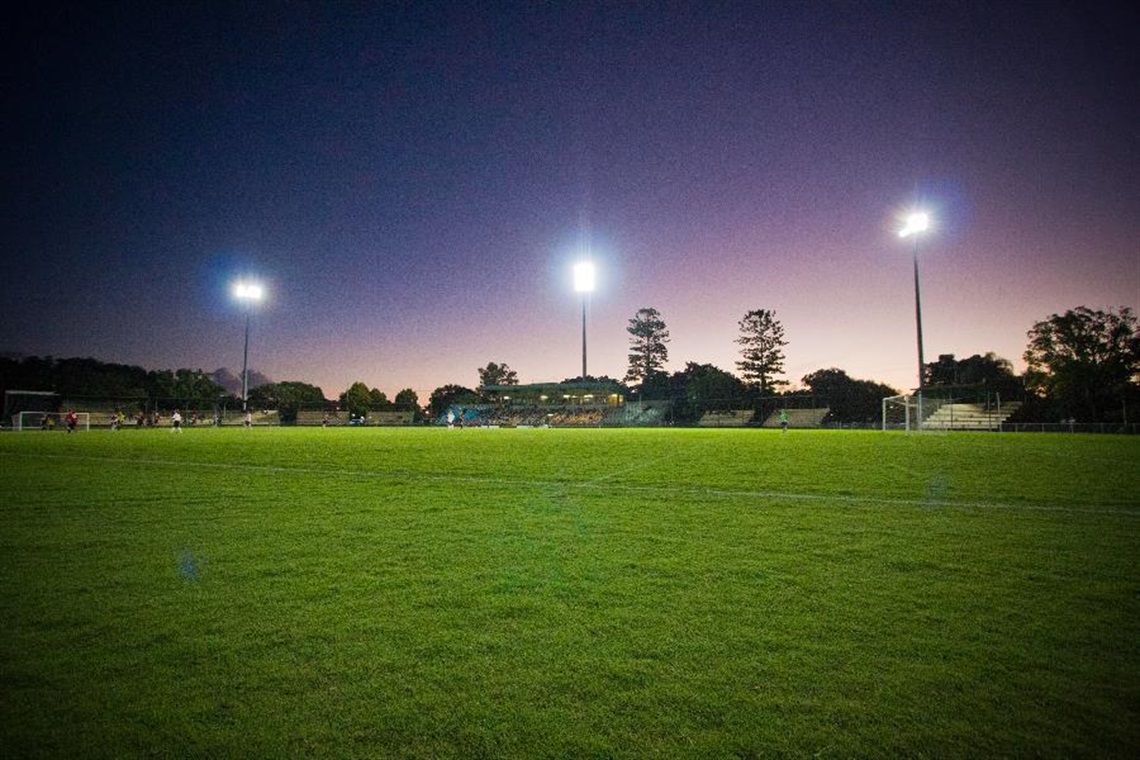 Oakes Oval in Lismore at night time with the stadium lights on.