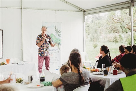 A volunteer talking to a workshop crowd.