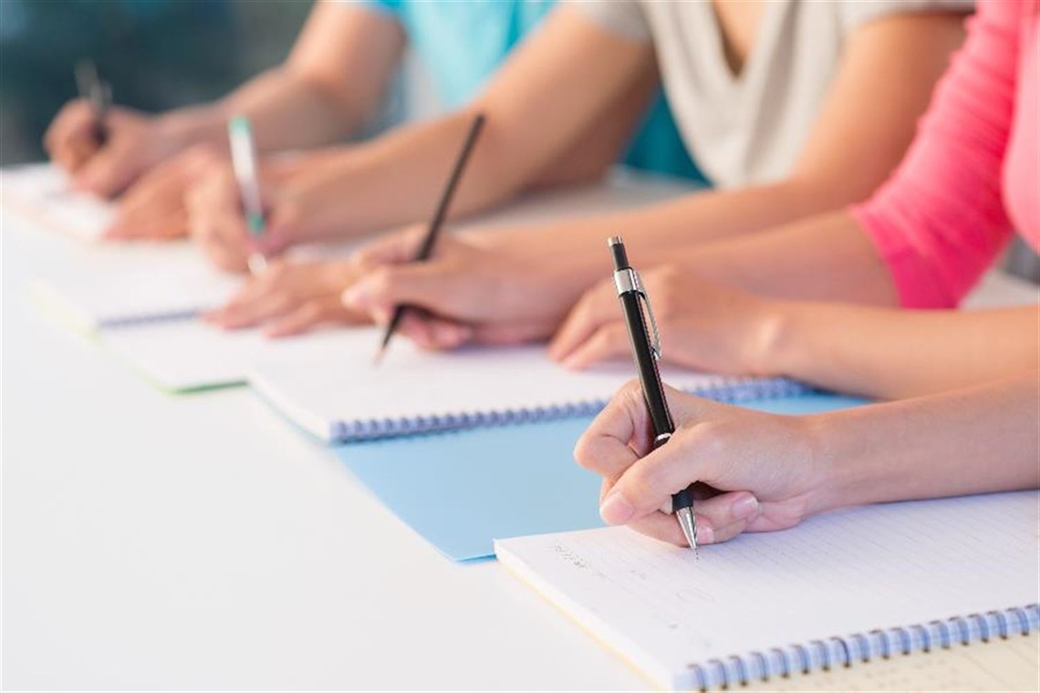people with notebooks and pens