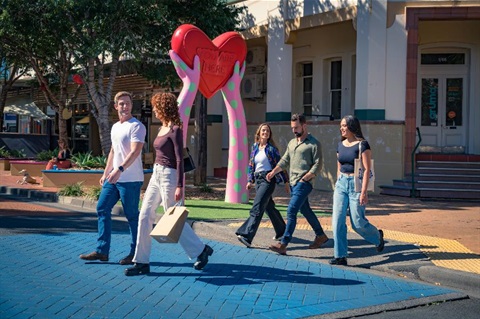 people crossing the road in front of the heart sculpture in the lismore cbd