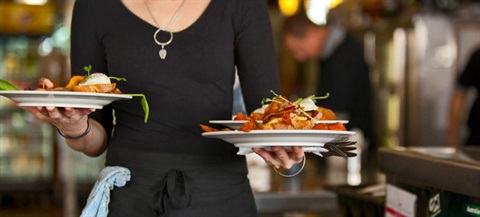 A waitress carrying plates of food.
