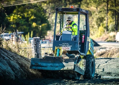 A council worker operating a road roller.